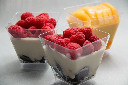A Delicate raspberry and mango panacotta decorated with fresh fruit.の写真素材