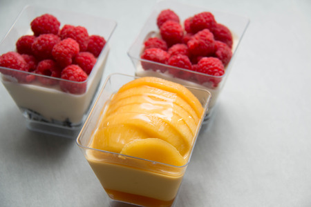 A Delicate raspberry and mango panacotta decorated with fresh fruit.の写真素材
