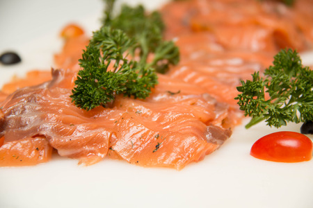 Smoked salmon slide cold on a plate with parsley.の写真素材