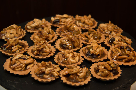 Piece of nut pie tart with various nuts on  boardの写真素材