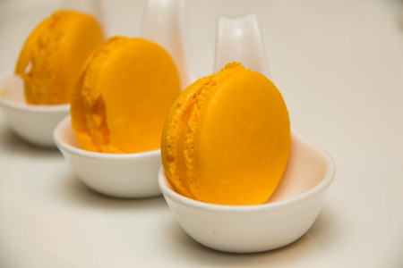 A Orange magaroon on white spoon cupの写真素材