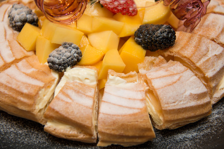 Profiteroles with fresh mango  a sweet background