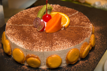 Close up of tiramisu cake with cocoa and macaroon