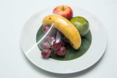 Fresh fruit in a plate on a white backgroundの写真素材