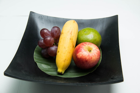 Fresh fruit in a wood bowl on a white backgroundの写真素材