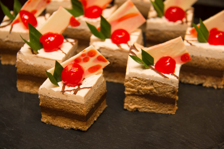 Appetizers mini desserts on catering buffet black tablecloth.