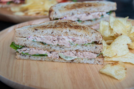 A tuna sandwich closeup with  tomatoes chip potatoの写真素材