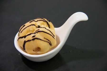 Mini vanilla eclair balls with chocolate sauce for party, selective focus 
の写真素材