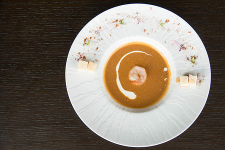 Shrimp soup in a white bowl and cream ontopの写真素材