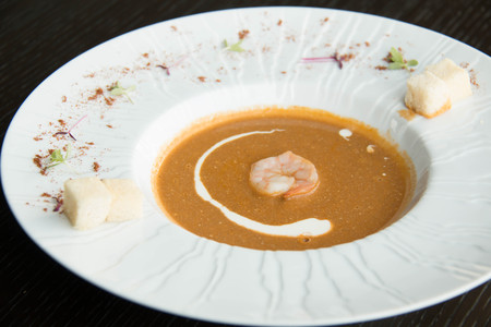 Shrimp soup in a white bowl and cream ontopの写真素材