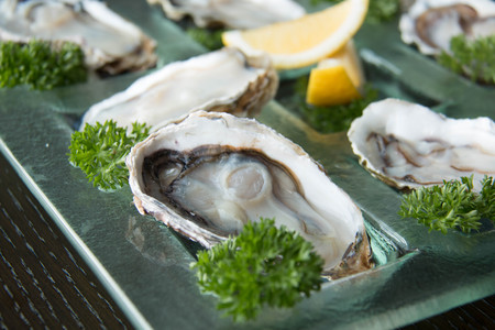 Opened Oysters on glass plate with spicy sauce