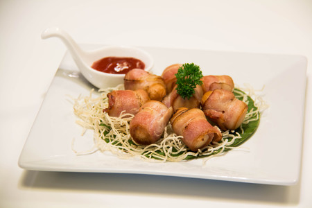 A Deep Fried Bacon Wrapped Sausage with sauceの写真素材