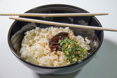 Instant noodles with seasoning in black bowl