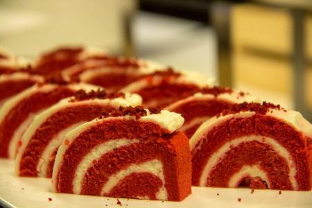 A red velvet cake roll sliced on a plateの写真素材