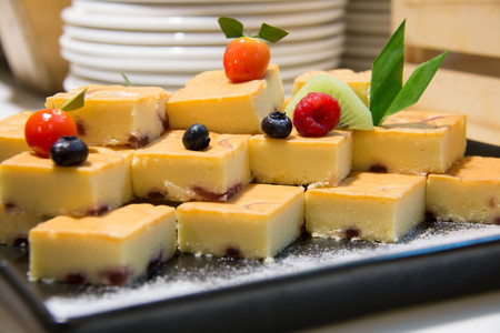 A mini cut butter cake on  black plateの写真素材