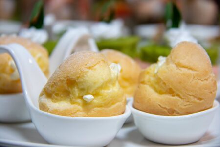 A delicious vanilla eclair on white spoon
