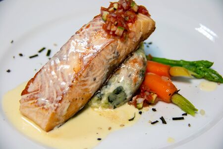 A salmon steak with sauce on plate の写真素材