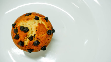 A chocolate chip muffin on white plate