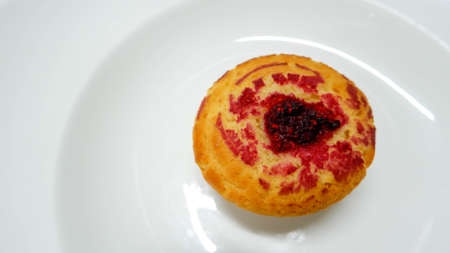 A raspberry muffin on a white background