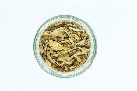 dried stevia leaves in bottle isolated on white background.