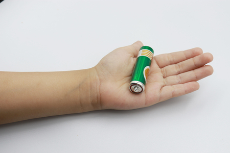 Battery AAA in kid hand on white background.の写真素材