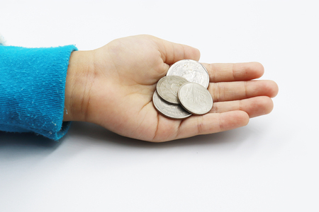 Kid hand showing money coins , child holding a coins on his hand isolate on white background, saving money for the future.の写真素材