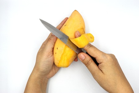 ripe mangoes, yellow mango peel with knife isolated on black background.の写真素材