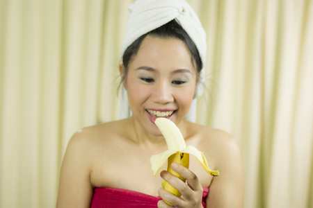 woman holding banana acting smile, sad, funny, wear a skirt to cover her breast after wash hair, Wrapped in Towels After Shower High resolution image gallery.の写真素材