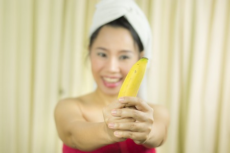 woman holding banana acting smile, sad, funny, wear a skirt to cover her breast after wash hair, Wrapped in Towels After Shower High resolution image gallery.の写真素材