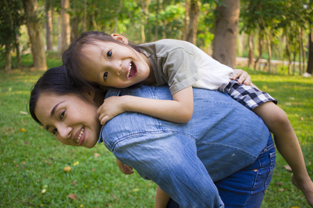 Lifestyle portrait mom and boy in happiness at the outside in the meadow, Funny Asian family in a green park High resolution image gallery.の写真素材