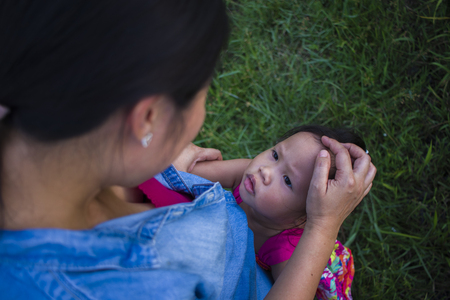 Young mother hugging and soothing a crying little daughter, Asian mother trying to comfort and calm down her crying child High resolution image gallery.の写真素材
