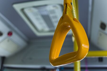yellow  hanging handhold for standing passengers in a modern bus. Suburban and urban transport