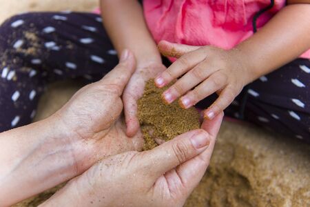 Lifestyle portrait mom son and daughter  playing with sand, Funny Asian family in a public  playground.の写真素材