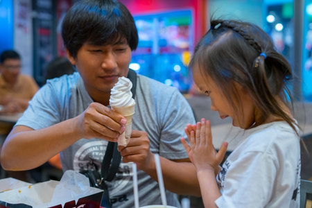 CHIANGMAI,THAILAND-Nov 14, 2019 : Little Child eating fried chicken with her family in the background of KFC (Kentucky Fried Chicken)restaurant.のeditorial素材