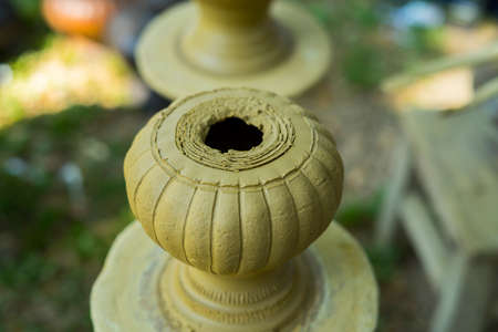 Clay potter creating on the pottery wheel. Sculptor from fresh wet clay on pottery wheel. Selected focus. potter was produced on range of pot in open airの写真素材