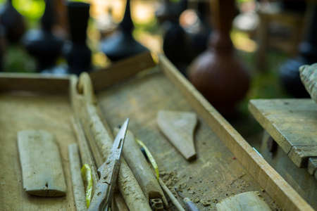 Clay potter creating on the pottery wheel. Sculptor from fresh wet clay on pottery wheel. Selected focus. potter was produced on range of pot in open airの写真素材