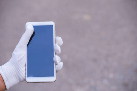 young asian woman cleaning mobile phone screen with soft paper napkin. virus prevention and disinfection.の写真素材