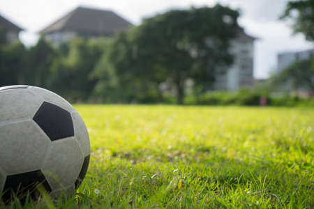 A ball for street soccer football under the sunset ray light in grass  field area with abstract lights blurred bokeh copy space.の写真素材