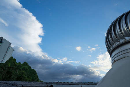 Cloud Blue sky and Roof Ventilator on roof of industryfor cooling in a natural way by relying on natural winds, selective focus and Low angle shotの写真素材