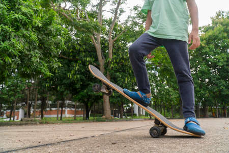 Asian little boy try to play skateboard stand and sit on it . Practice and practice to play.の写真素材