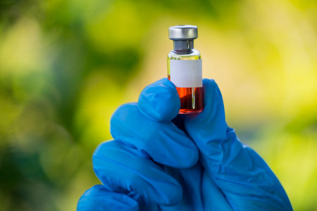 female doctor hand wears medical glove holding syringe and vial bottle, flu medicine treatment vaccination concept.の写真素材