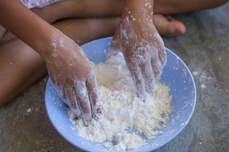 hand of asian children are preparing the dough, bake cookies in the kitchenの写真素材