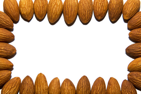 Close-up of almonds. The frame is made of almonds. On white background. Isolated.の写真素材