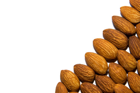 Close-up of almonds. Almonds in the corner. From the side. On white background. Isolated.の写真素材