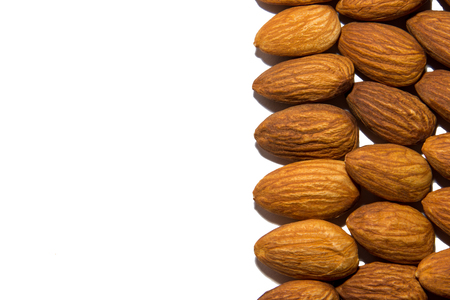 Close-up of almonds. Almonds in the corner. From the side. On white background. Isolated.の写真素材