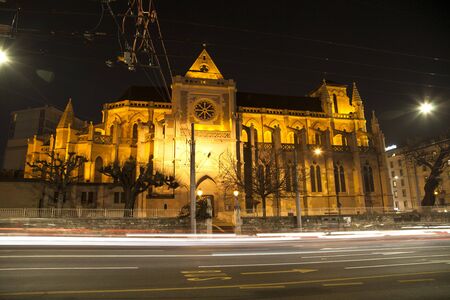 Crossroad photographed in a long exposition with light trails and a parliament building in the background. Speed concept.の写真素材
