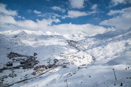 Panoramic view of ski resort three valleys and big lift in french alps - Vacation and travel concept - Winter high season opening with people having fun on mountain - Focus on sport equipmentの写真素材