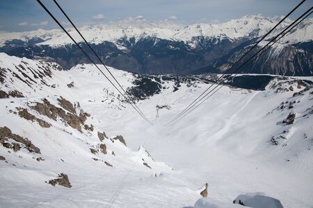 Panoramic view of ski resort three valleys and big lift in french alps - Vacation and travel concept - Winter high season opening with people having fun on mountain - Focus on sport equipmentの写真素材