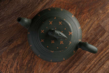 Top view of green traditional chinese Yixin clay teapot with cicada on the cover. On the wooden tableの写真素材