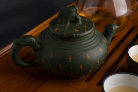 Green traditional chinese Yixin clay teapot with cicada on the cover and accesories for tea ceremonyの写真素材
